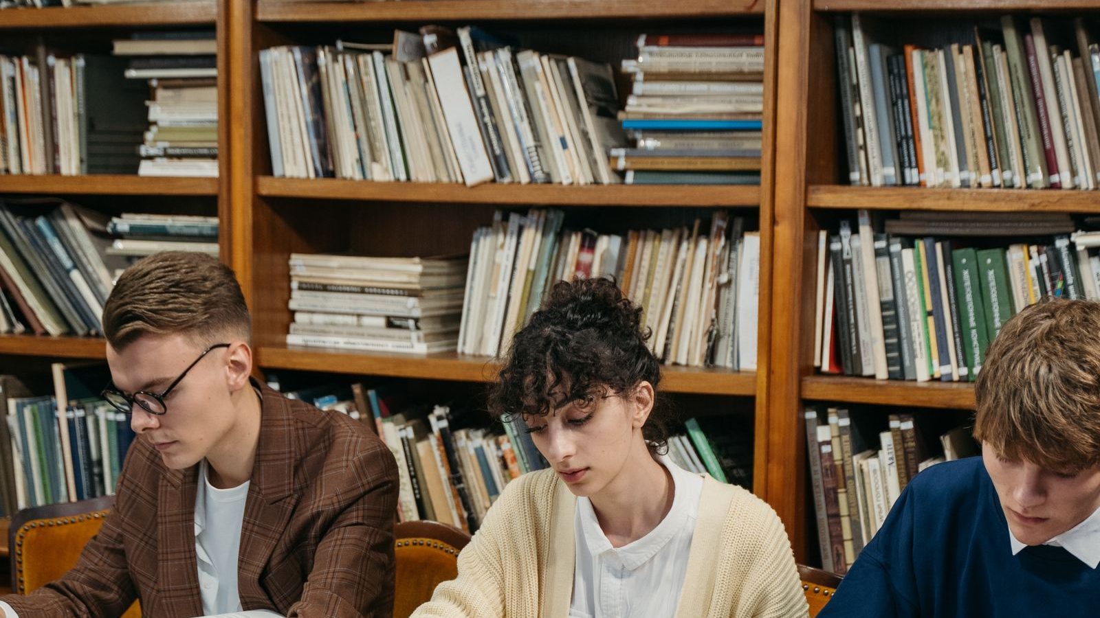 Estudiantes estudiando en biblioteca universitaria.